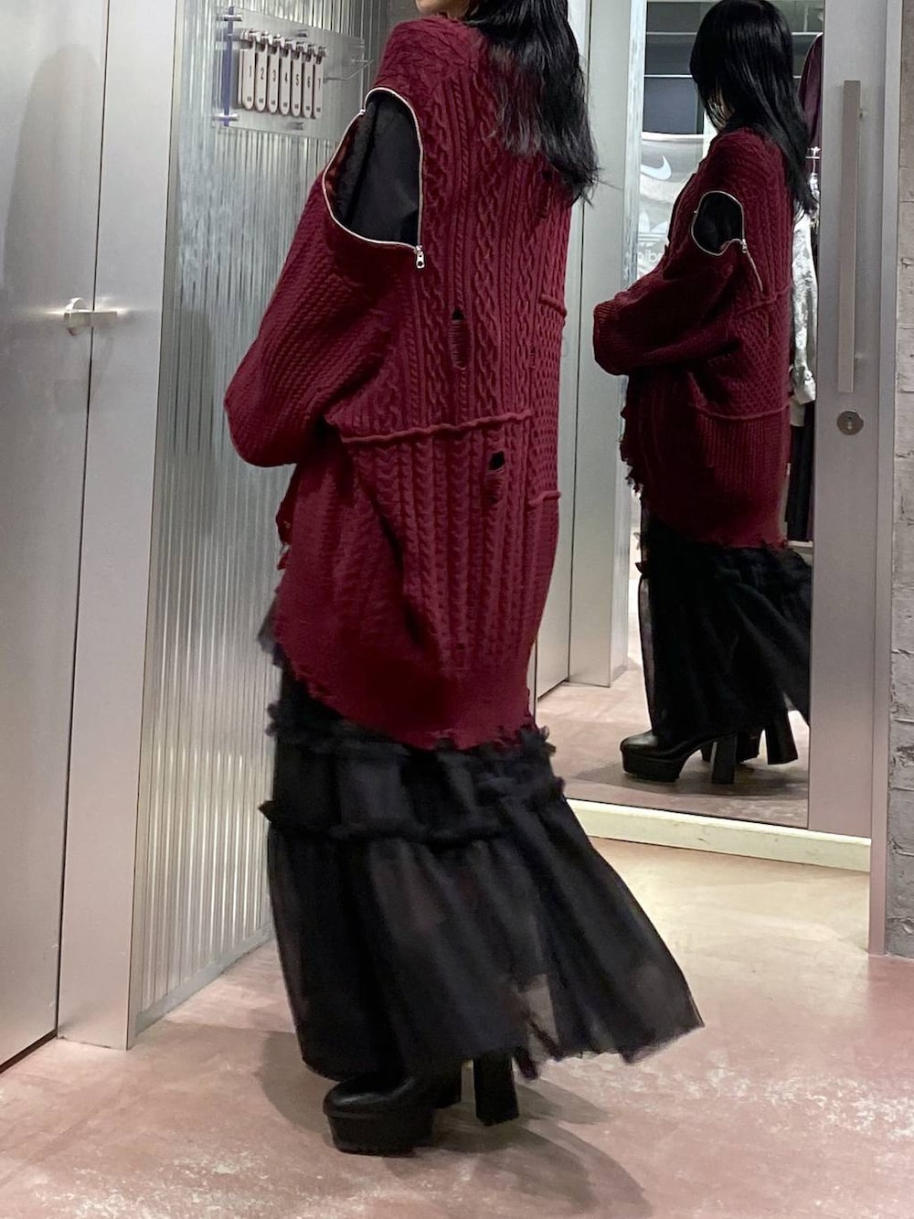 ブラック系のブーツ、レッド系のカーディガン/ボレロ、ブラック系のスカートを着用したレディースの秋コーディネートの7枚目の写真