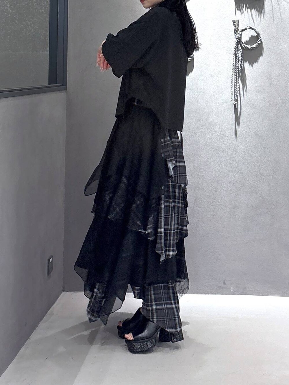 ブラック系のタンクトップ、グレー系のサンダル、ブラック系のスカートを着用したレディースの夏コーディネートの2枚目の写真