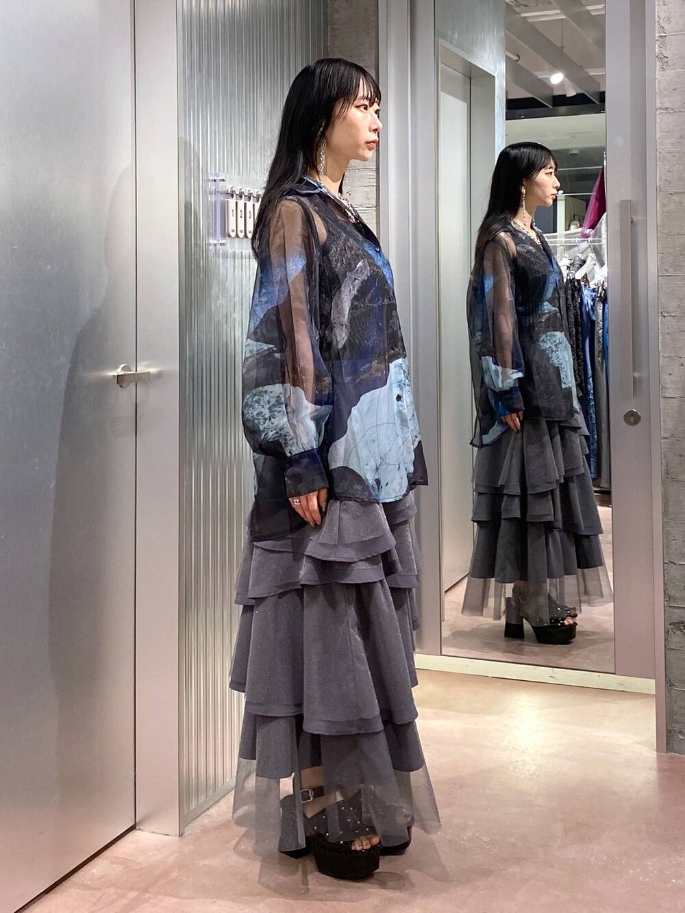 ブラック系のサンダル、ブラック系のタンクトップ、グレー系のスカートを着用したレディースの夏コーディネートの4枚目の写真