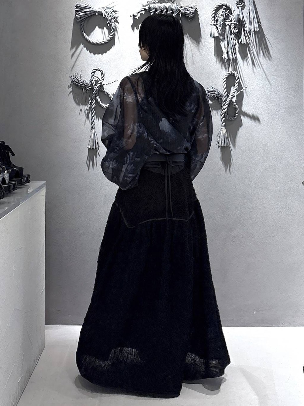 ブラック系のパンプス、ブラック系のタンクトップ、ブラック系のスカートを着用したレディースの春コーディネートの2枚目の写真