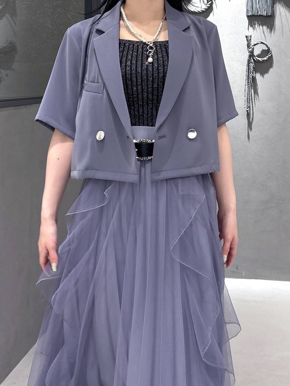 ブラック系のタンクトップ、パープル系のスカート、ブラック系のサンダルを着用したレディースの春コーディネートの6枚目の写真