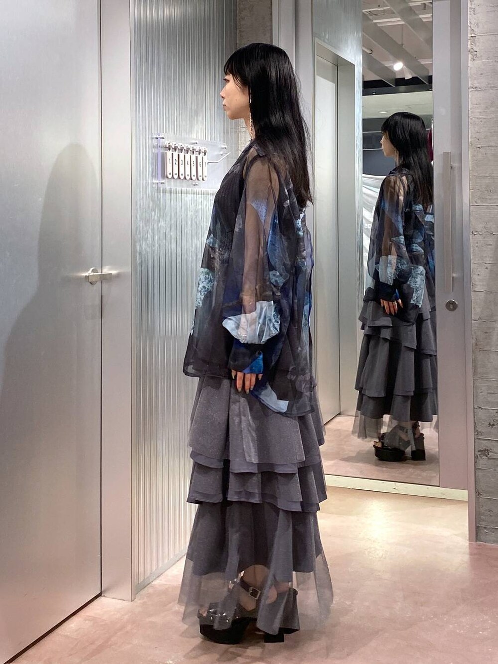 ブラック系のサンダル、ブラック系のタンクトップ、グレー系のスカートを着用したレディースの夏コーディネートの2枚目の写真