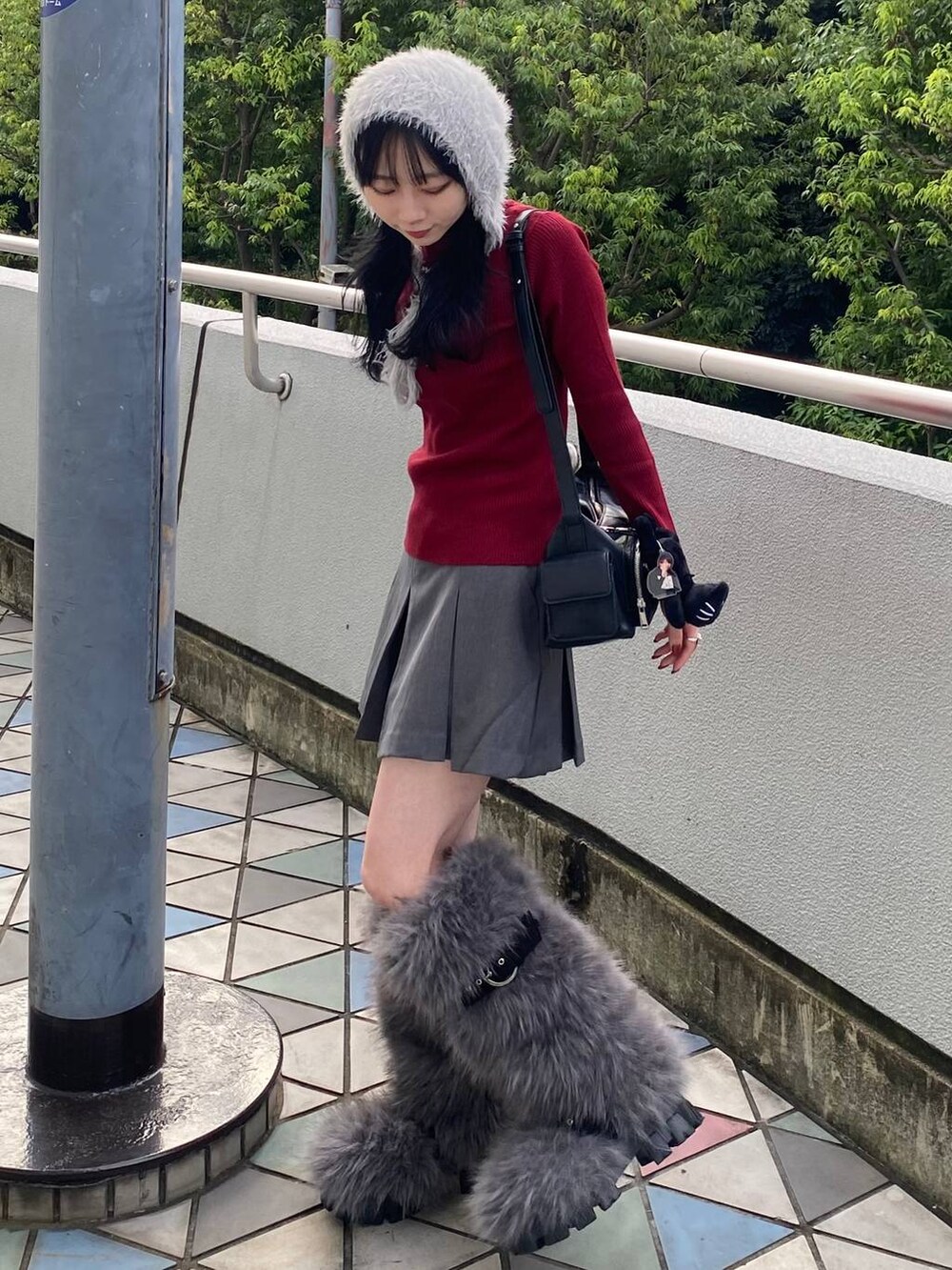 ブラック系のショルダーバッグ、レッド系のニット/セーター、グレー系のその他パンツを着用したレディースの秋コーディネートの2枚目の写真