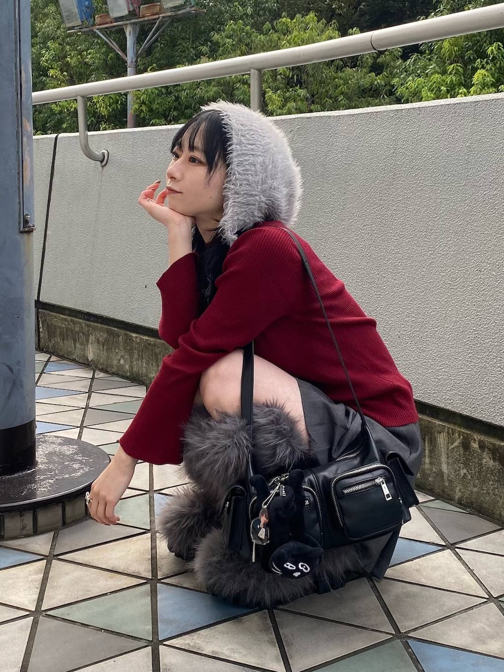 ブラック系のショルダーバッグ、レッド系のニット/セーター、グレー系のその他パンツを着用したレディースの秋コーディネートの4枚目の写真