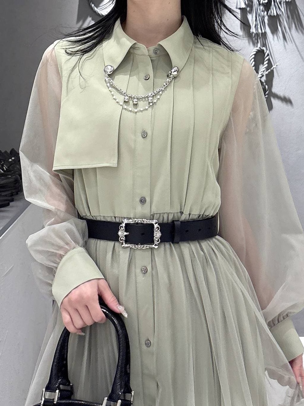 ブラック系のパンプス、ブラック系のショルダーバッグ、イエロー系のワンピースを着用したレディースの春コーディネートの7枚目の写真