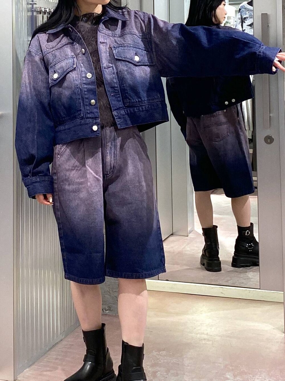 グレー系のニット/セーター、ブラック系のブーツ、パープル系のデニムジャケットを着用したレディースの冬コーディネートの6枚目の写真