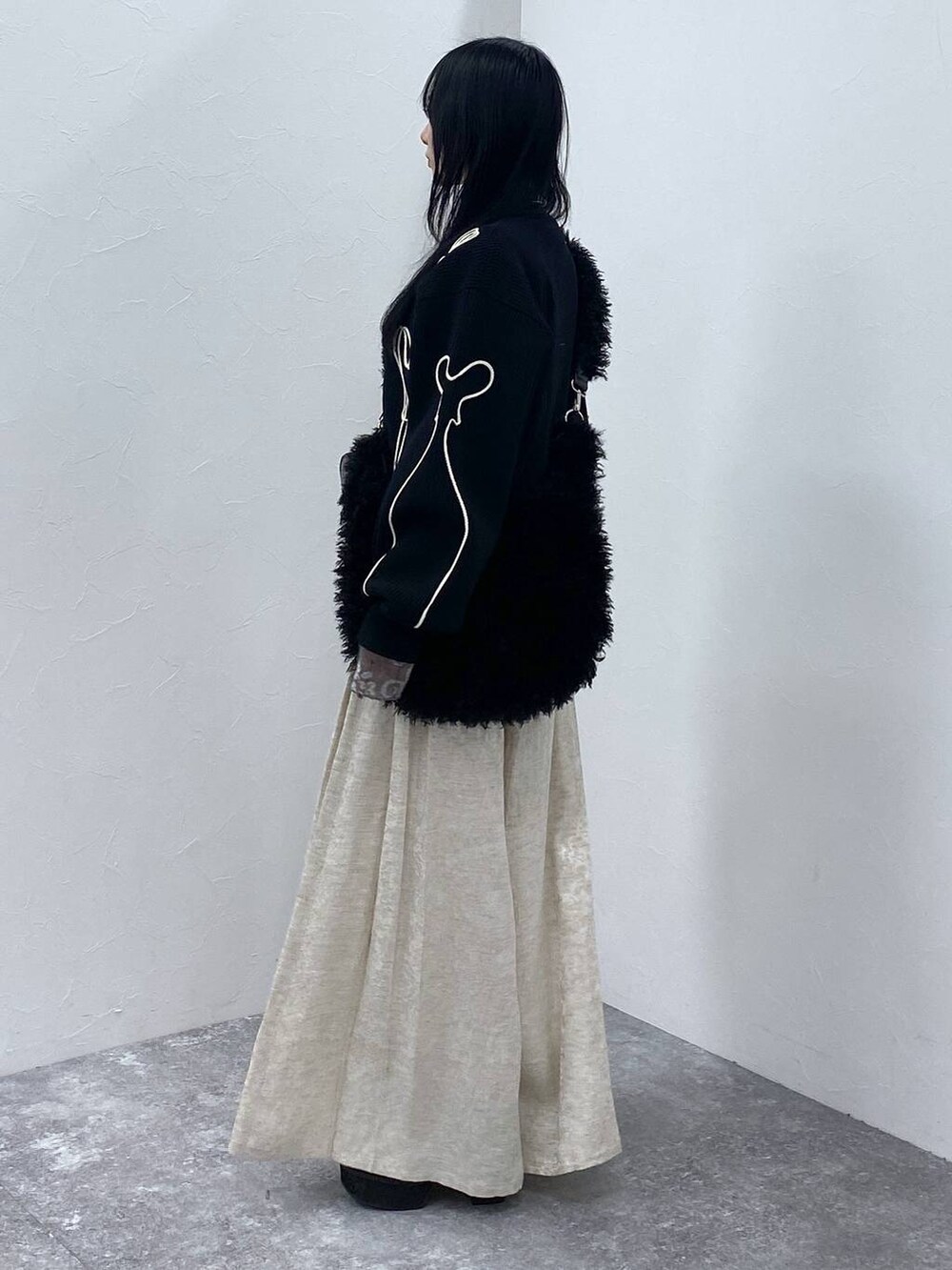 ブラック系のブーツ、ブラック系のショルダーバッグ、ブラック系のニット/セーターを着用したレディースの冬コーディネートの2枚目の写真