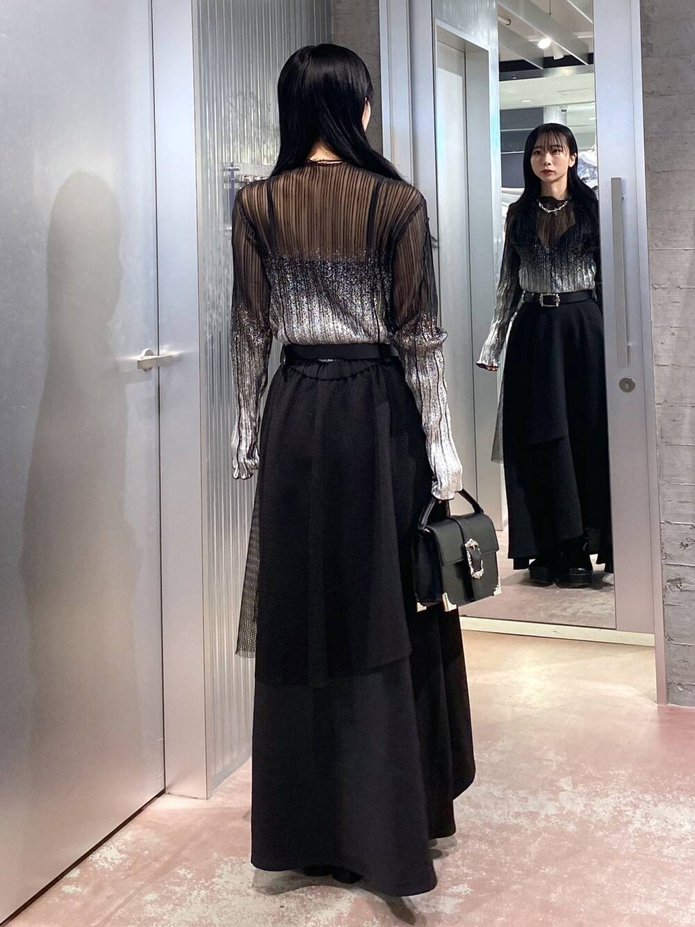 ブラック系のブーツ、ブラック系のショルダーバッグ、ブラック系のTシャツ/カットソーを着用したレディースの冬コーディネートの3枚目の写真