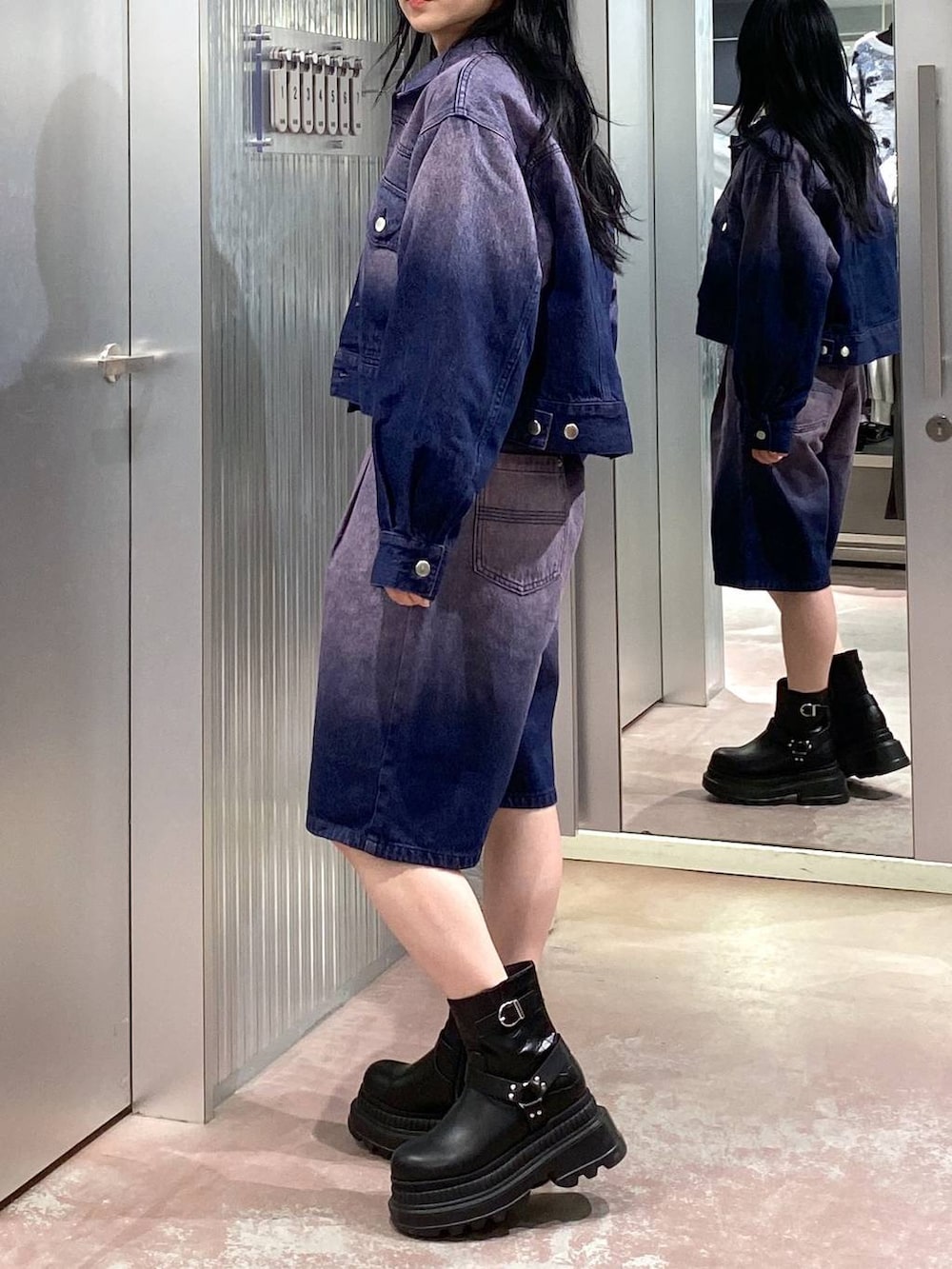 グレー系のニット/セーター、ブラック系のブーツ、パープル系のデニムジャケットを着用したレディースの冬コーディネートの9枚目の写真