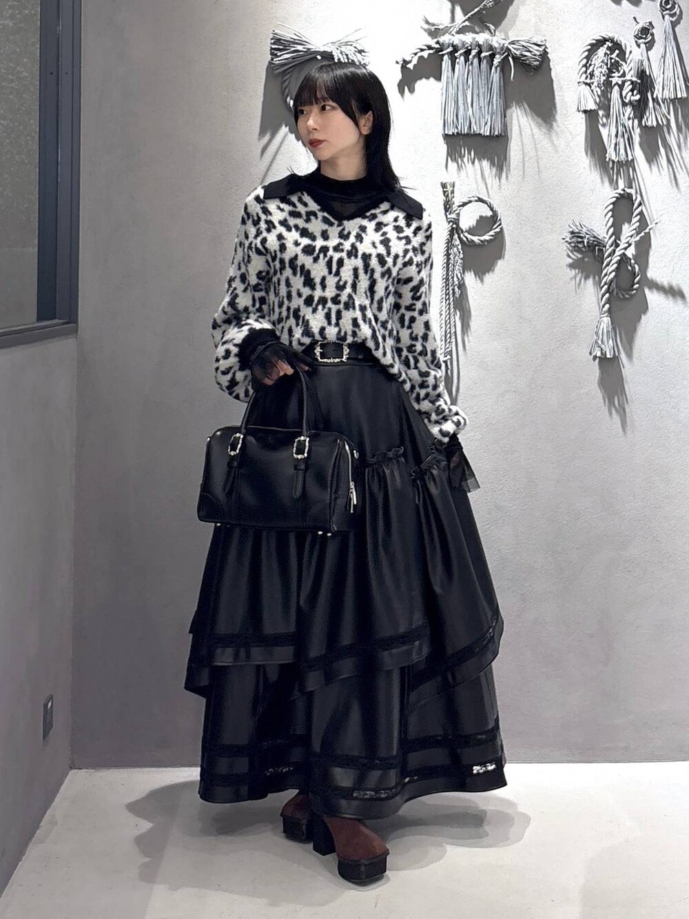 ブラック系のTシャツ/カットソー、ブラック系のボストンバッグ、ブラウン系のブーツを着用したレディースの秋コーディネートの9枚目の写真