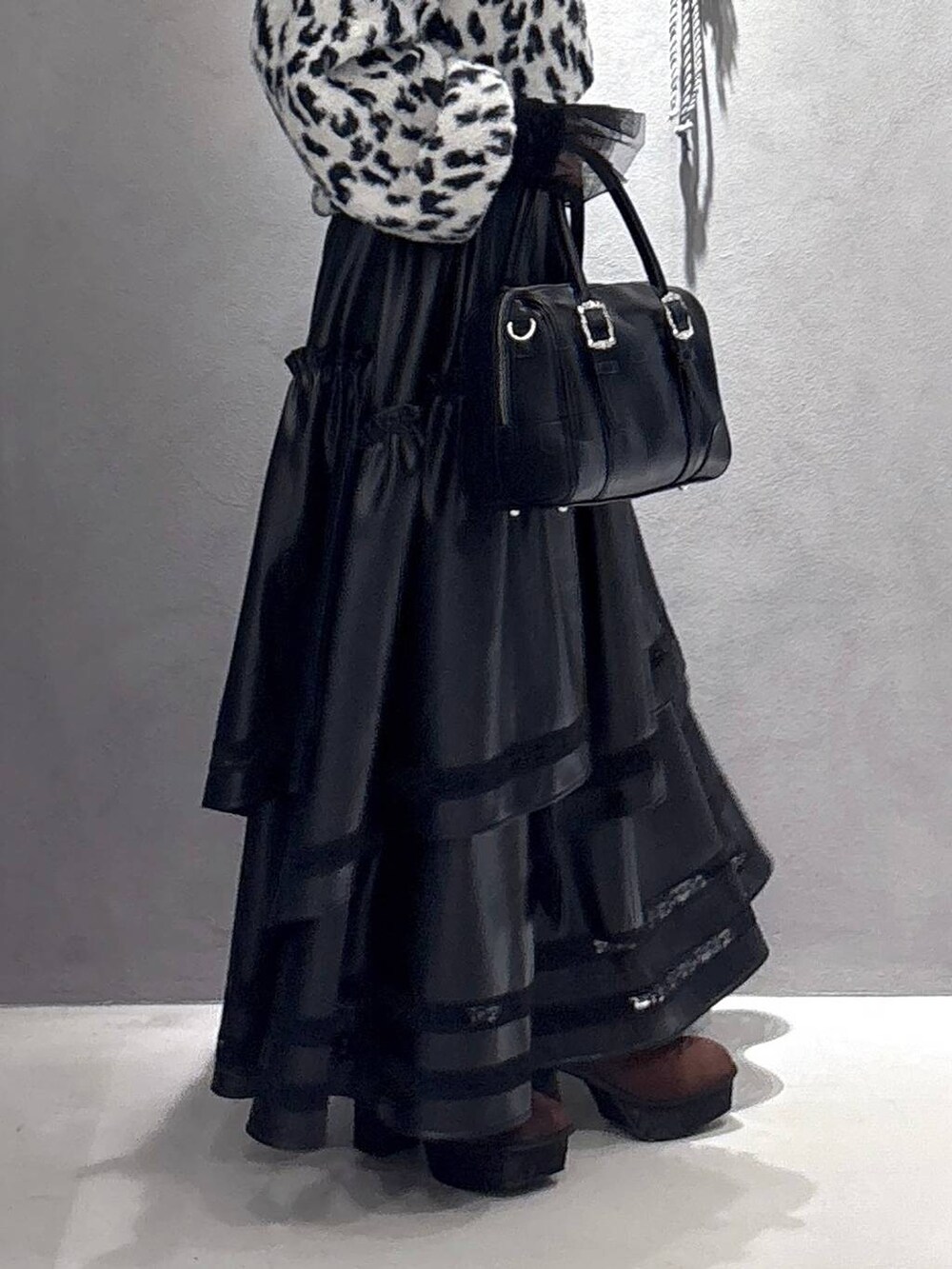 ブラック系のTシャツ/カットソー、ブラック系のボストンバッグ、ブラウン系のブーツを着用したレディースの秋コーディネートの4枚目の写真