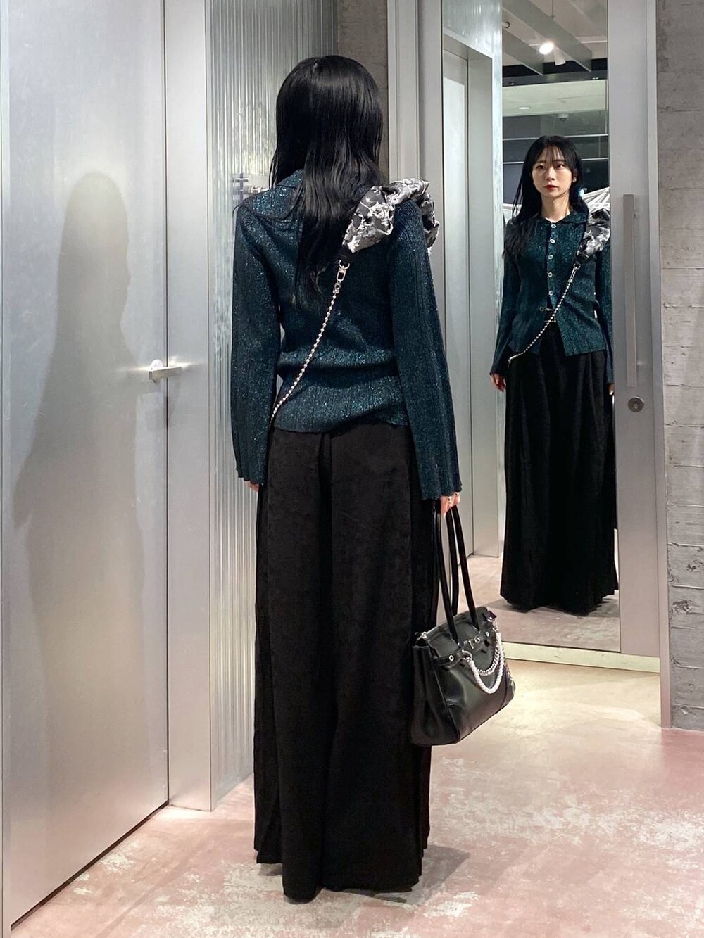 ブラック系のブーツ、ブラック系のボストンバッグ、グリーン系のカーディガン/ボレロを着用したレディースの冬コーディネートの3枚目の写真