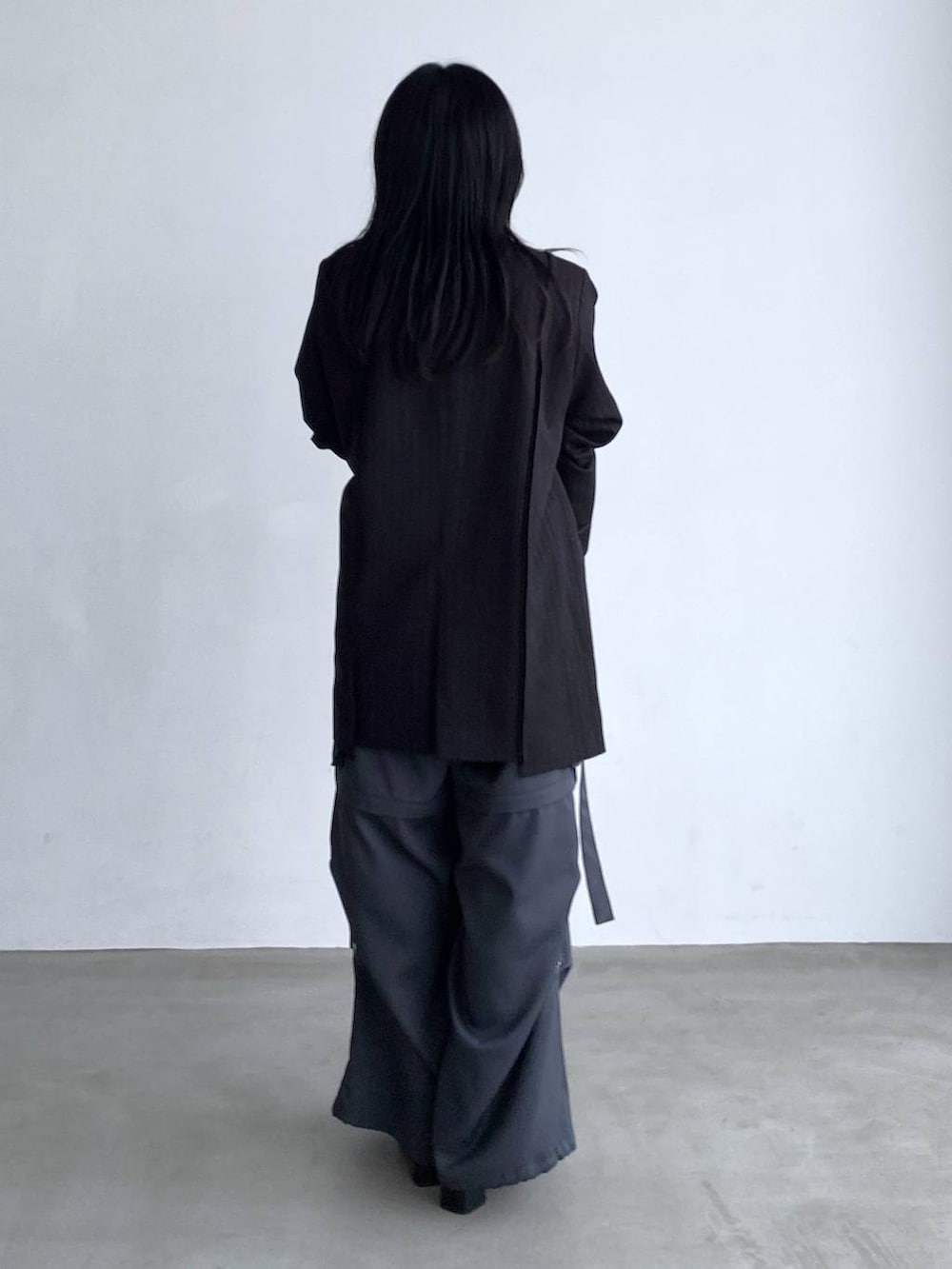 グレー系のカーゴパンツ、シルバー系のブーツ、ブラック系のテーラードジャケットを着用したレディースの夏コーディネートの3枚目の写真