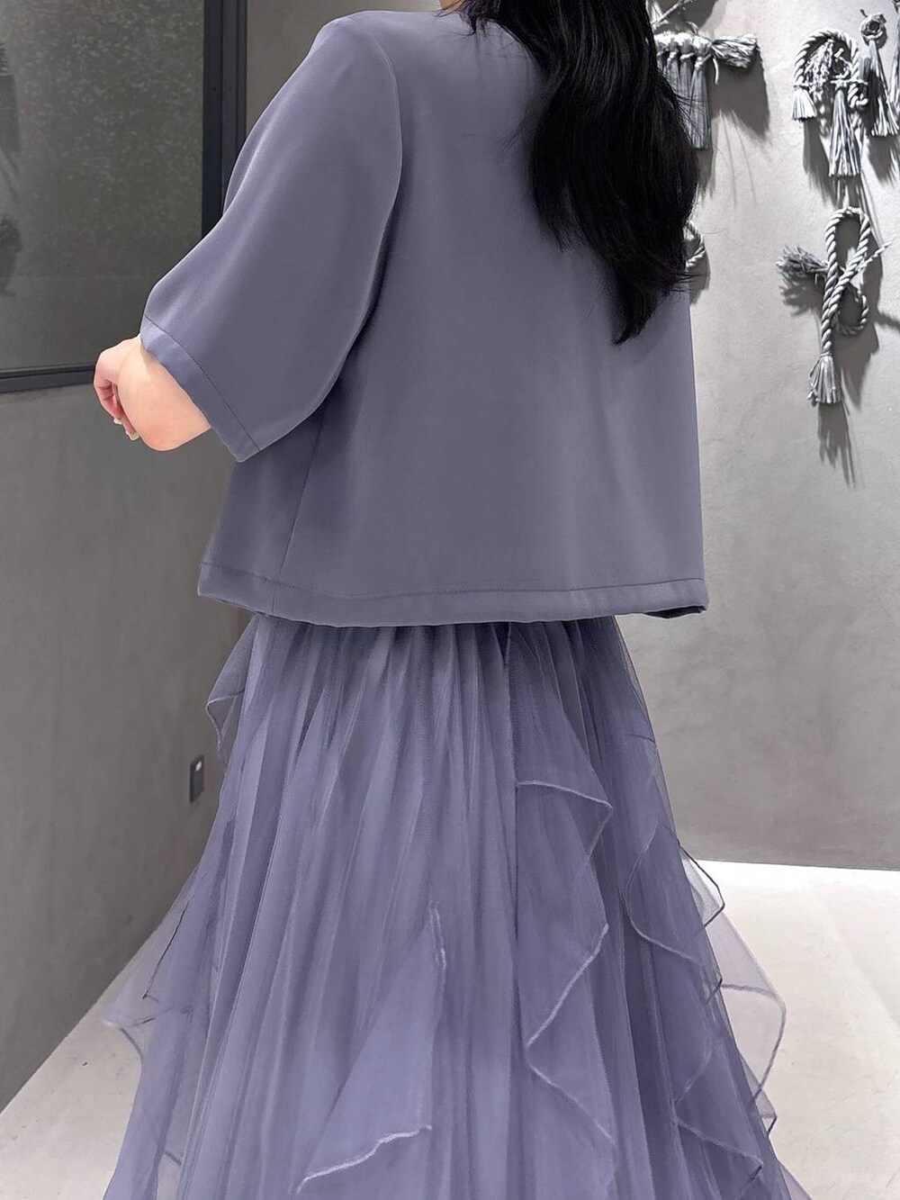 ブラック系のタンクトップ、パープル系のスカート、ブラック系のサンダルを着用したレディースの春コーディネートの7枚目の写真