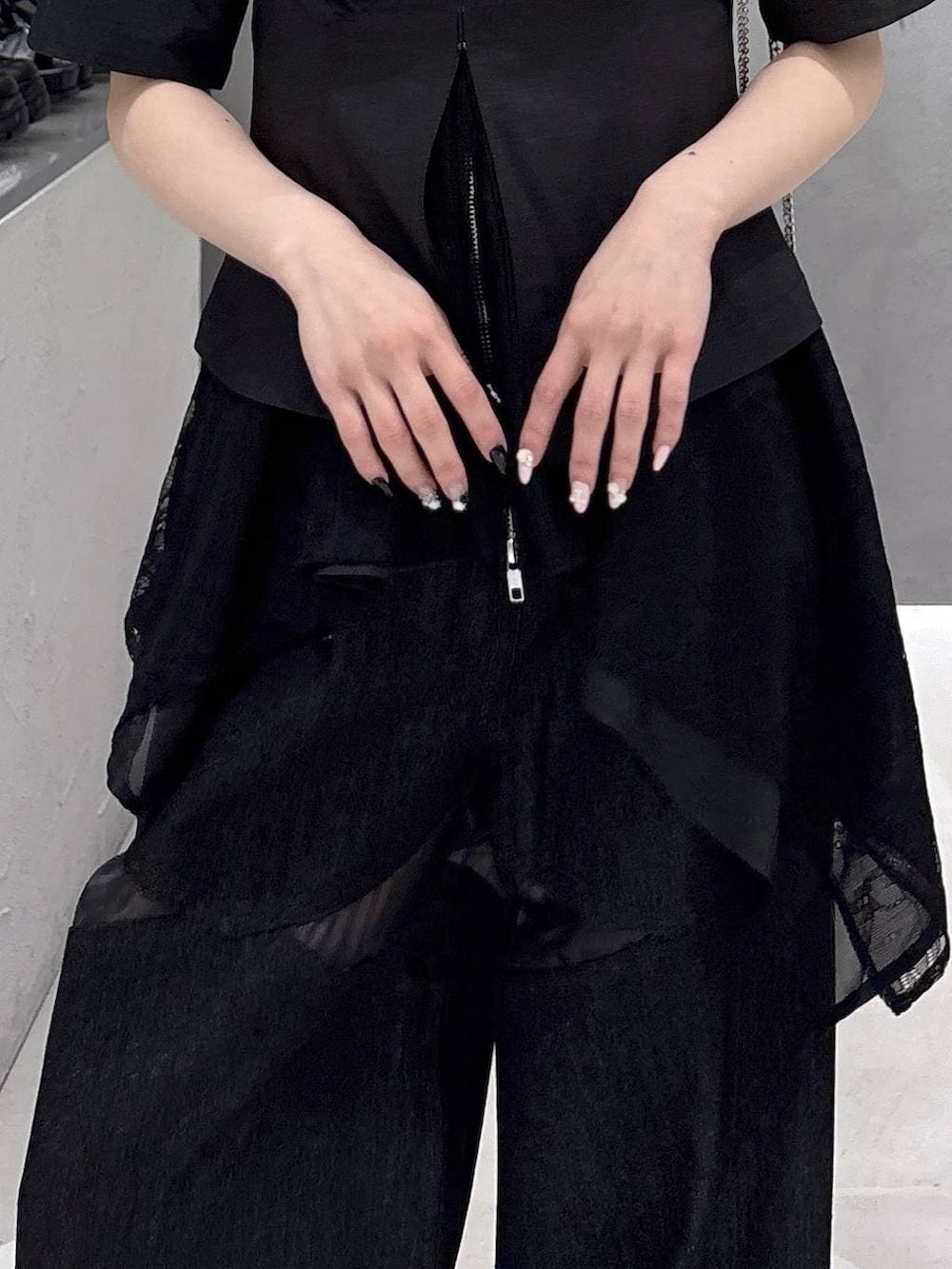 ブラック系のタンクトップ、ブラック系のサンダル、ブラック系のデニムパンツを着用したレディースの春コーディネートの9枚目の写真