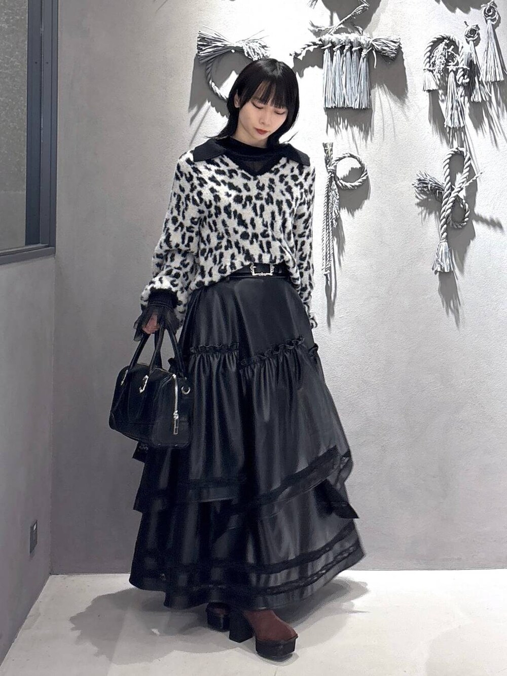 ブラック系のTシャツ/カットソー、ブラック系のボストンバッグ、ブラウン系のブーツを着用したレディースの秋コーディネートの5枚目の写真