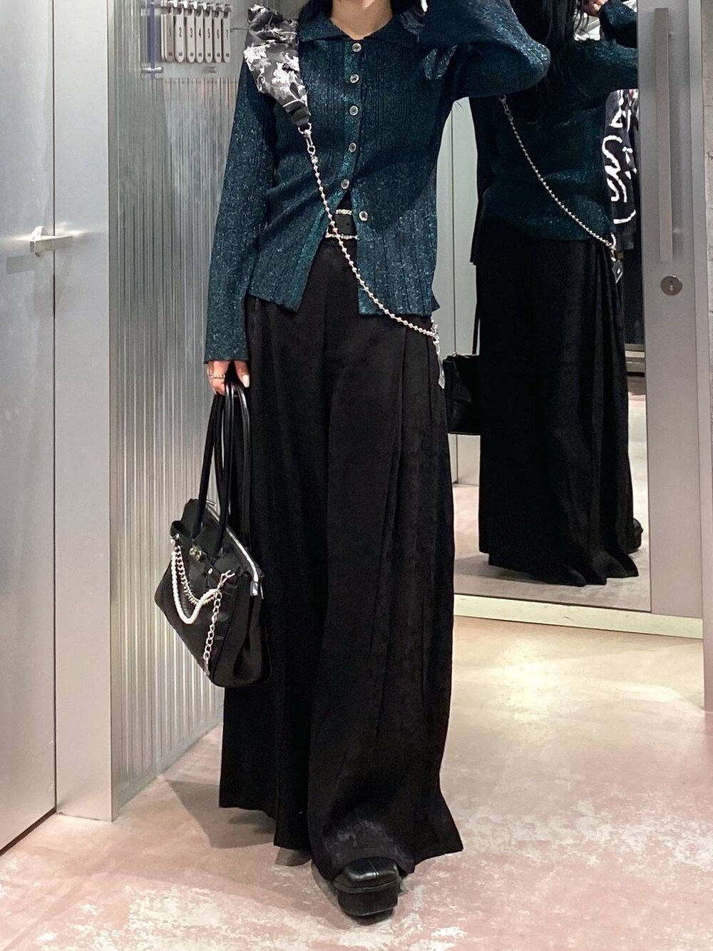 ブラック系のブーツ、ブラック系のボストンバッグ、グリーン系のカーディガン/ボレロを着用したレディースの冬コーディネートの5枚目の写真