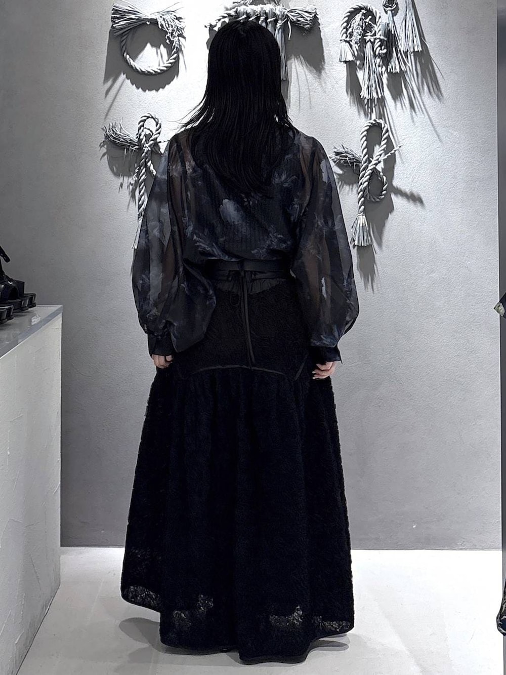 ブラック系のパンプス、ブラック系のタンクトップ、ブラック系のスカートを着用したレディースの春コーディネートの3枚目の写真