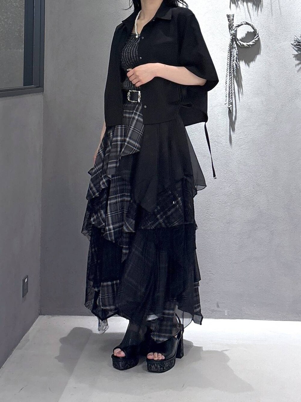 ブラック系のタンクトップ、グレー系のサンダル、ブラック系のスカートを着用したレディースの夏コーディネートの5枚目の写真