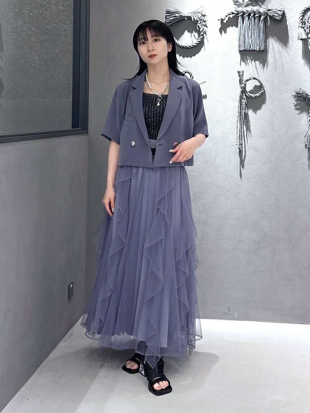 ブラック系のタンクトップ、パープル系のスカート、ブラック系のサンダルを着用したレディースの春コーディネートの5枚目の写真