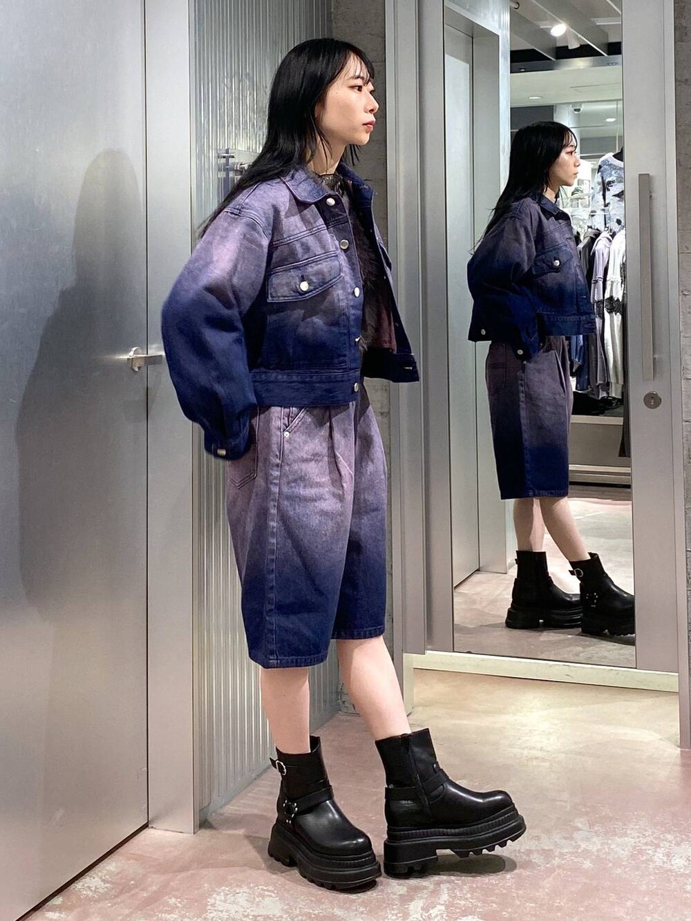 グレー系のニット/セーター、ブラック系のブーツ、パープル系のデニムジャケットを着用したレディースの冬コーディネートの4枚目の写真