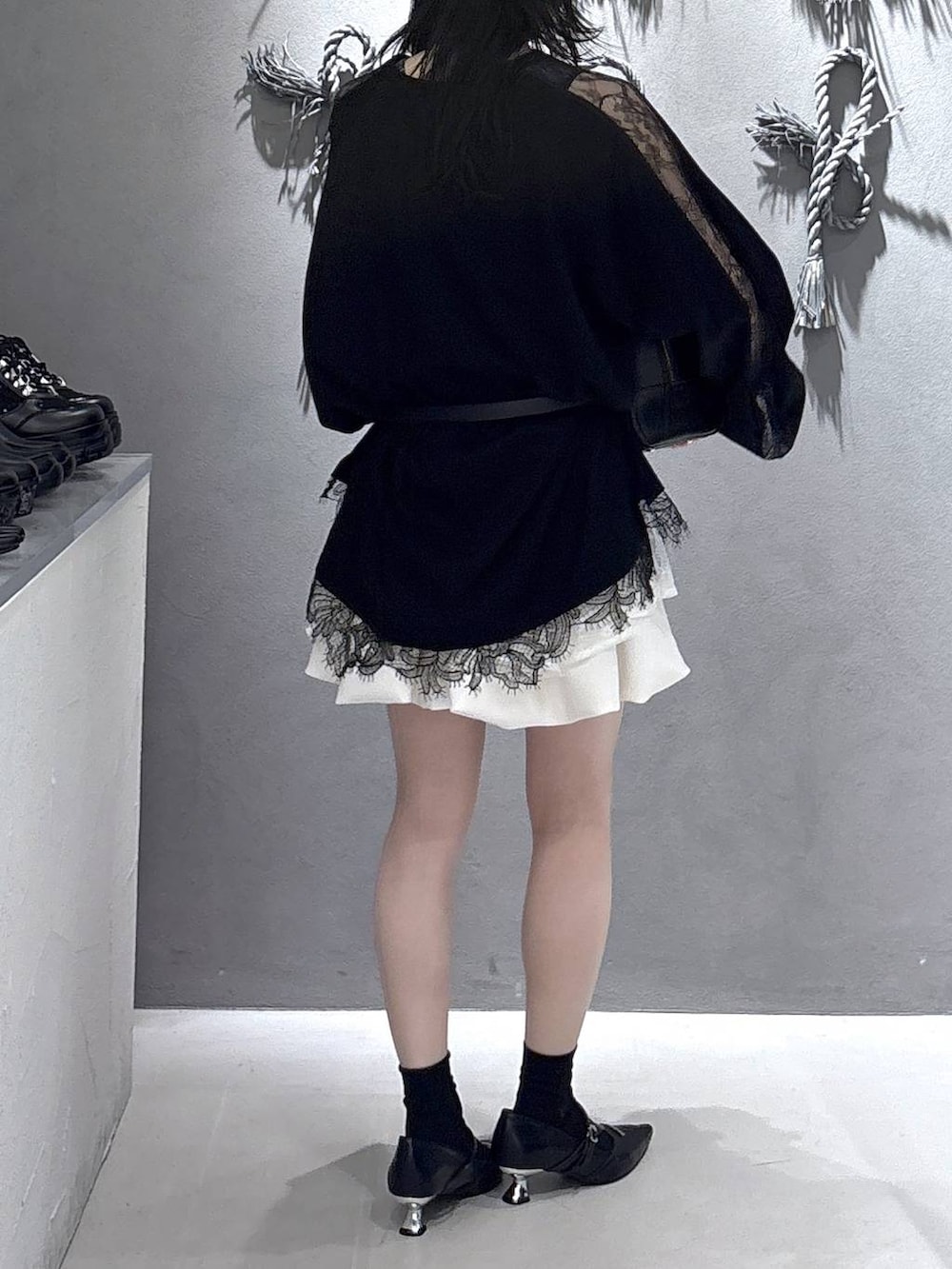 ブラック系のボストンバッグ、ブラック系のパンプス、ホワイト系のスカートを着用したレディースの冬コーディネートの3枚目の写真