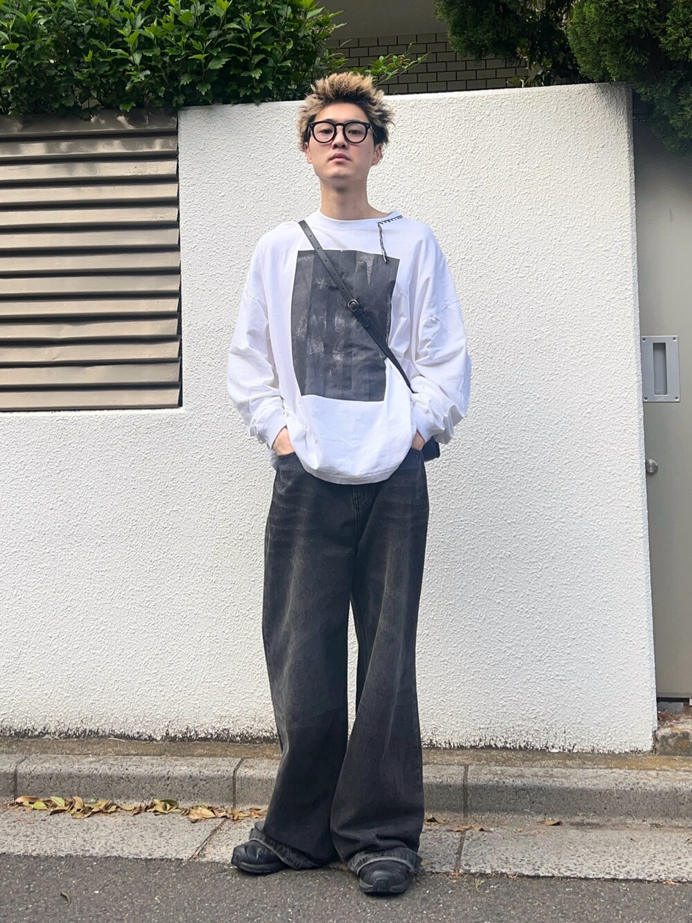 ホワイト系のTシャツ/カットソー、ブラック系のデニムパンツ、ブラック系のスニーカーを着用したメンズの春コーディネートの2枚目の写真