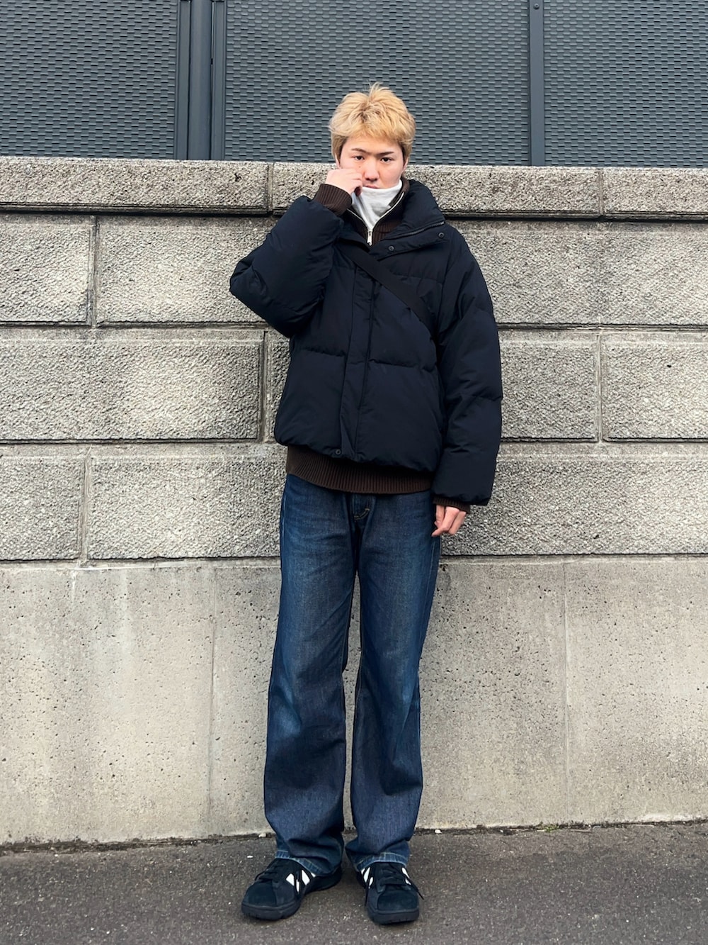 ブラック系のダウンジャケット/コート、ブラウン系のニット/セーター、ホワイト系のTシャツ/カットソーを着用したメンズの冬コーディネートの2枚目の写真