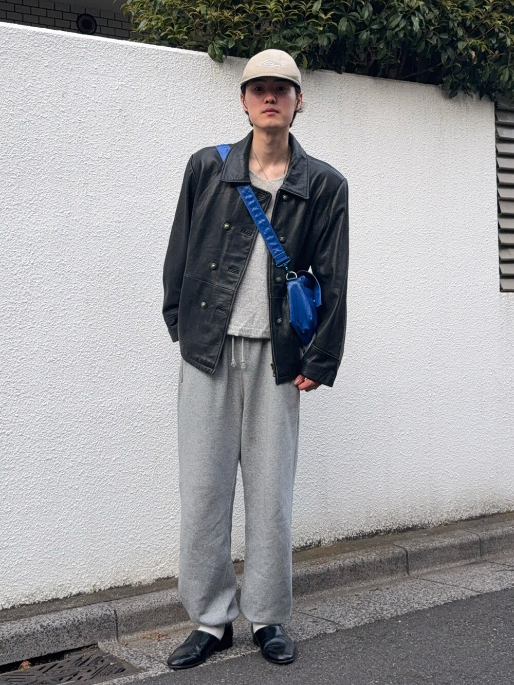 ブラック系のジャケット/アウター、グレー系のニット/セーター、グレー系のスウェットパンツを着用したメンズの春コーディネートの2枚目の写真