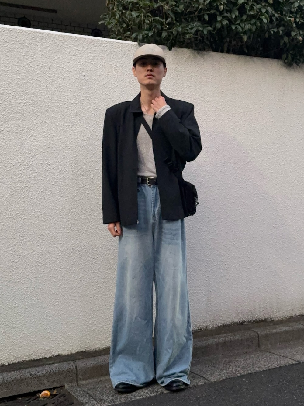 ブラック系のジャケット/アウター、グレー系のニット/セーター、ブルー系のデニムパンツを着用したメンズの秋コーディネートの2枚目の写真