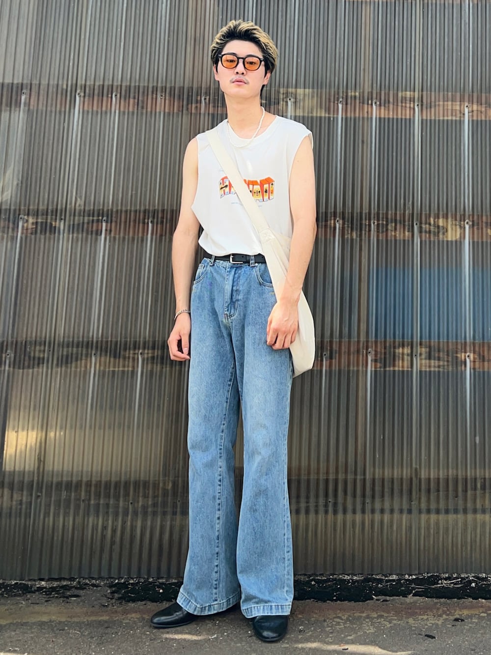ホワイト系のタンクトップ、ブルー系のデニムパンツ、ブラック系のドレスシューズを着用したメンズの夏コーディネートの2枚目の写真