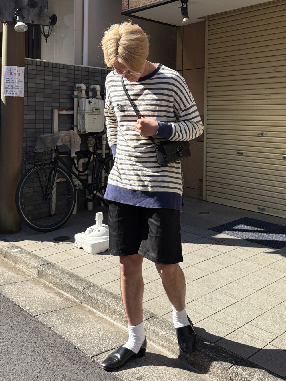 ブラック系のショルダーバッグ、ブラック系のドレスシューズ、ホワイト系のTシャツ/カットソーを着用したメンズの春コーディネートの2枚目の写真