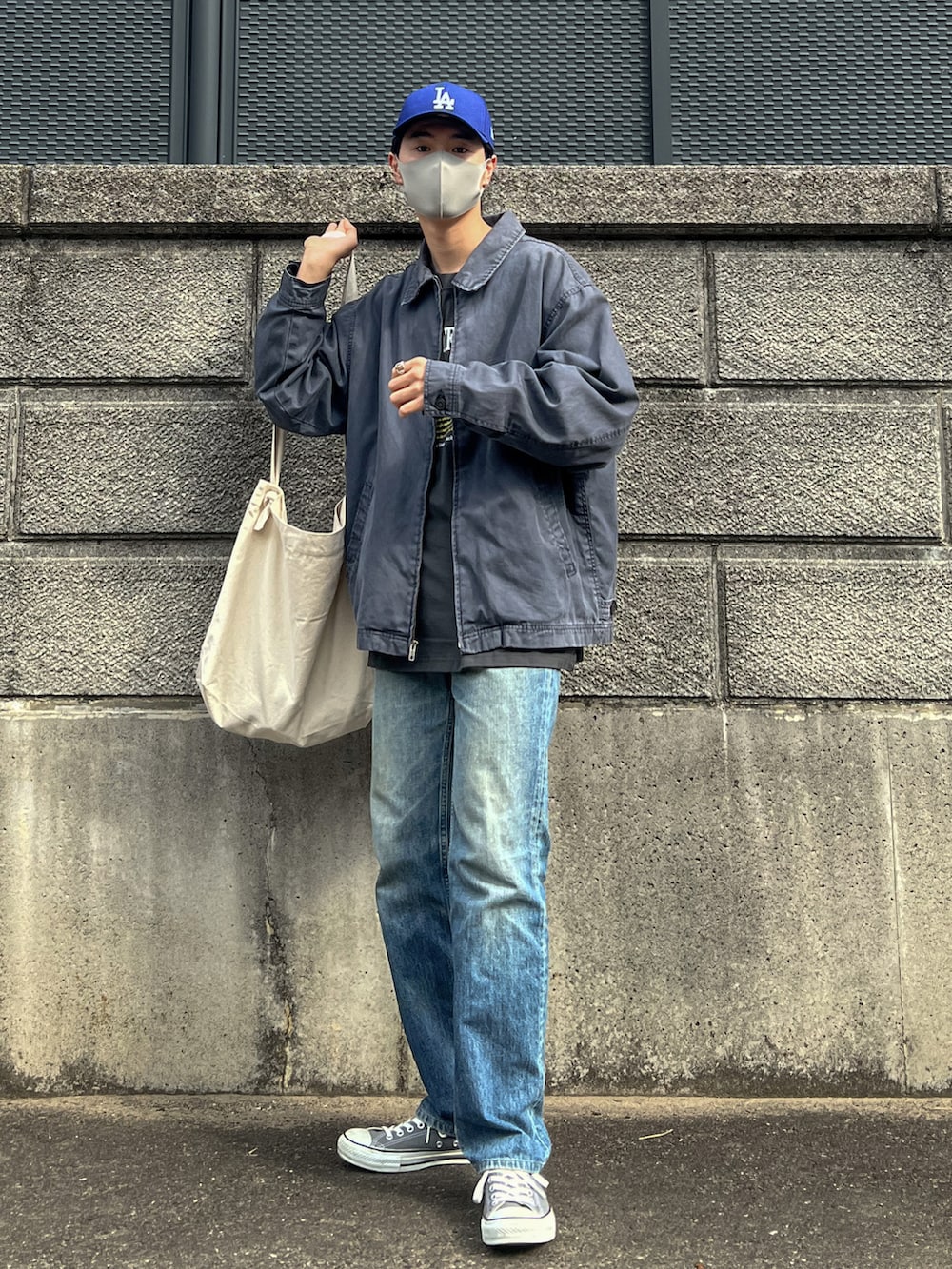 ブルー系のブルゾン、グレー系のTシャツ/カットソー、ブルー系のデニムパンツを着用したメンズの秋コーディネートの2枚目の写真