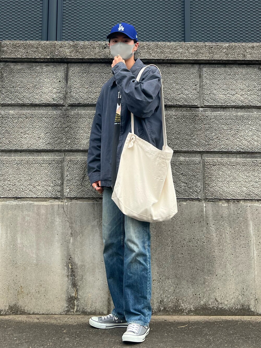 ブルー系のブルゾン、グレー系のTシャツ/カットソー、ブルー系のデニムパンツを着用したメンズの秋コーディネートの3枚目の写真
