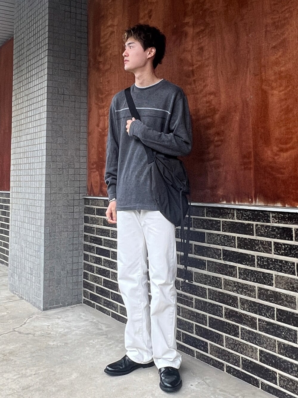 グレー系のニット/セーター、ホワイト系のパンツ、ブラック系のドレスシューズを着用したメンズの秋コーディネートの4枚目の写真