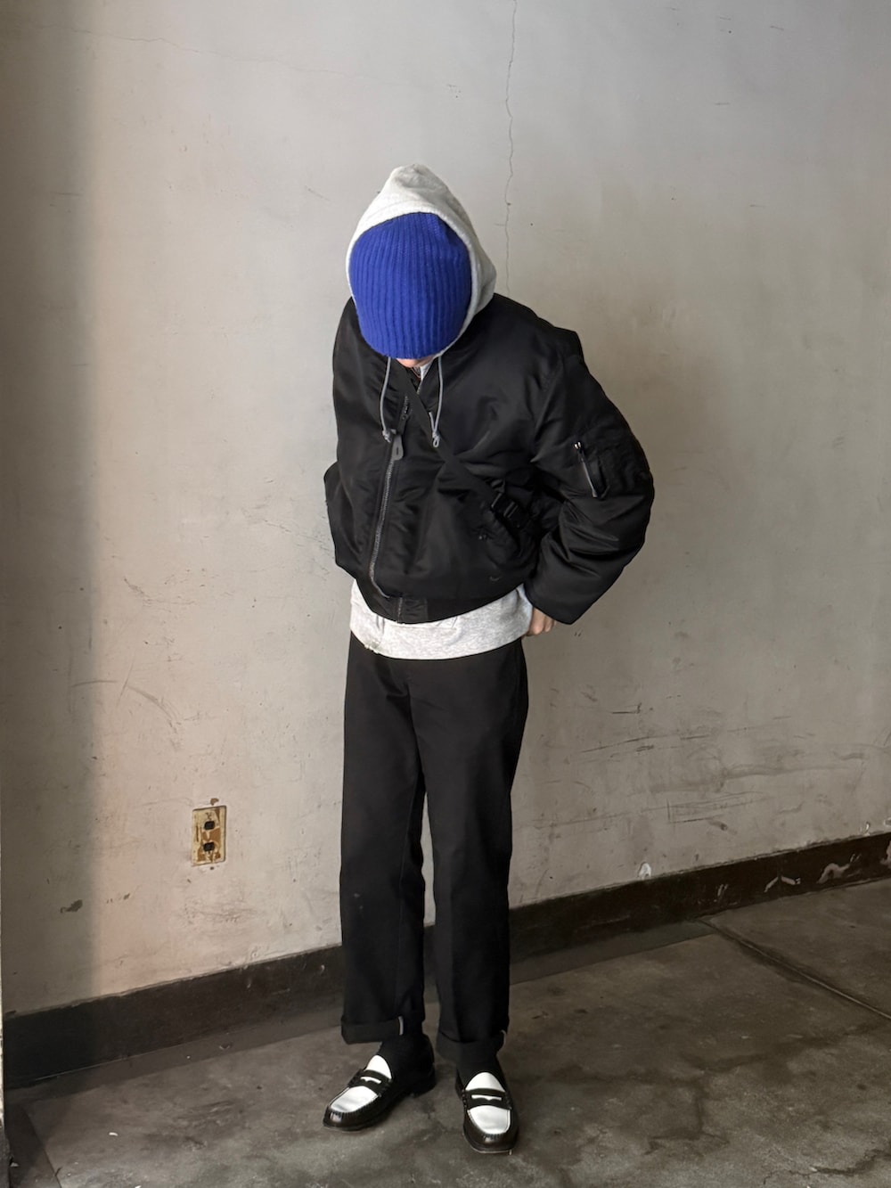 ブラック系のMA-1、グレー系のパーカー、ホワイト系のTシャツ/カットソーを着用したメンズの冬コーディネートの2枚目の写真