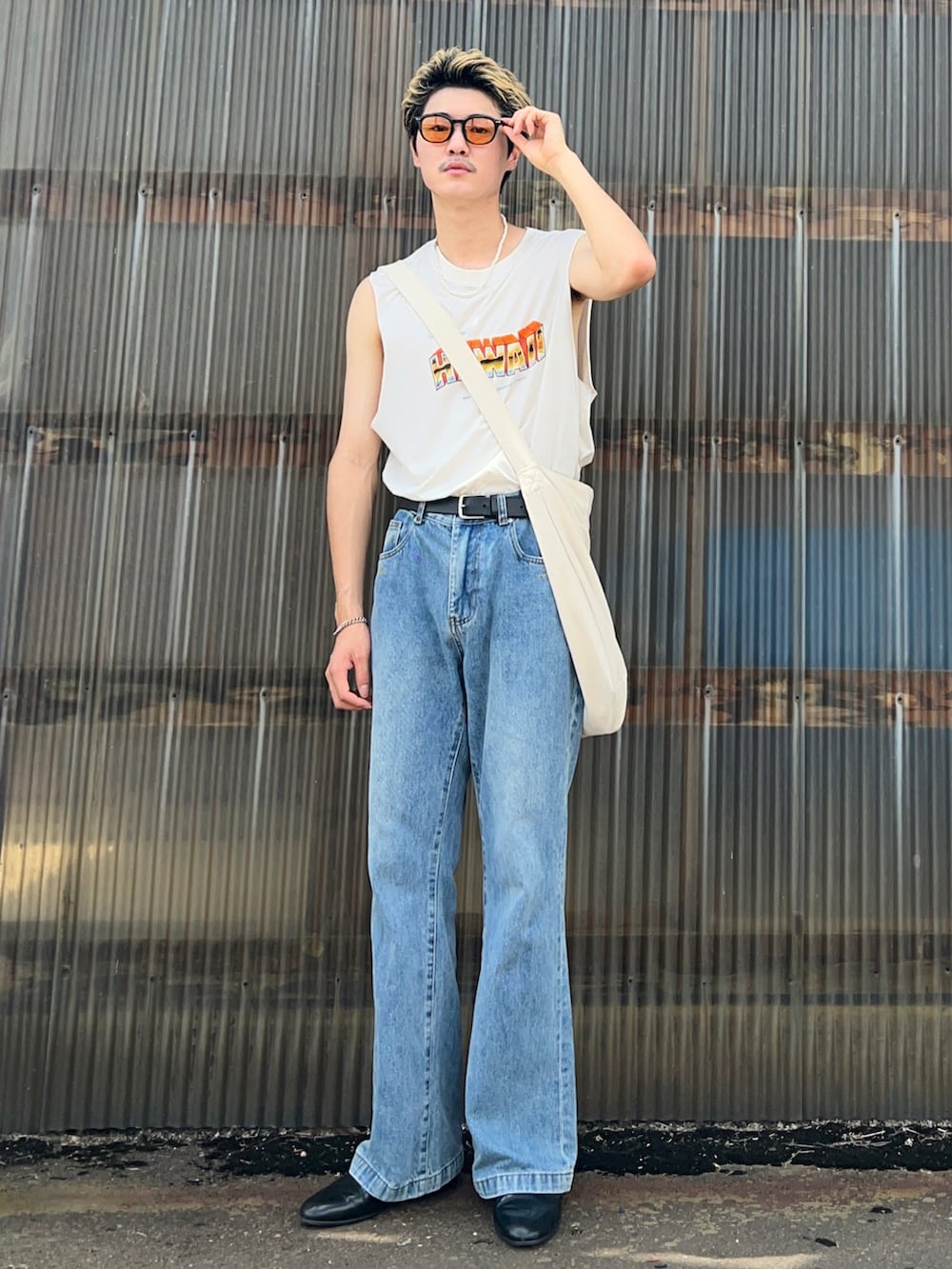 ホワイト系のタンクトップ、ブルー系のデニムパンツ、ブラック系のドレスシューズを着用したメンズの夏コーディネートの3枚目の写真