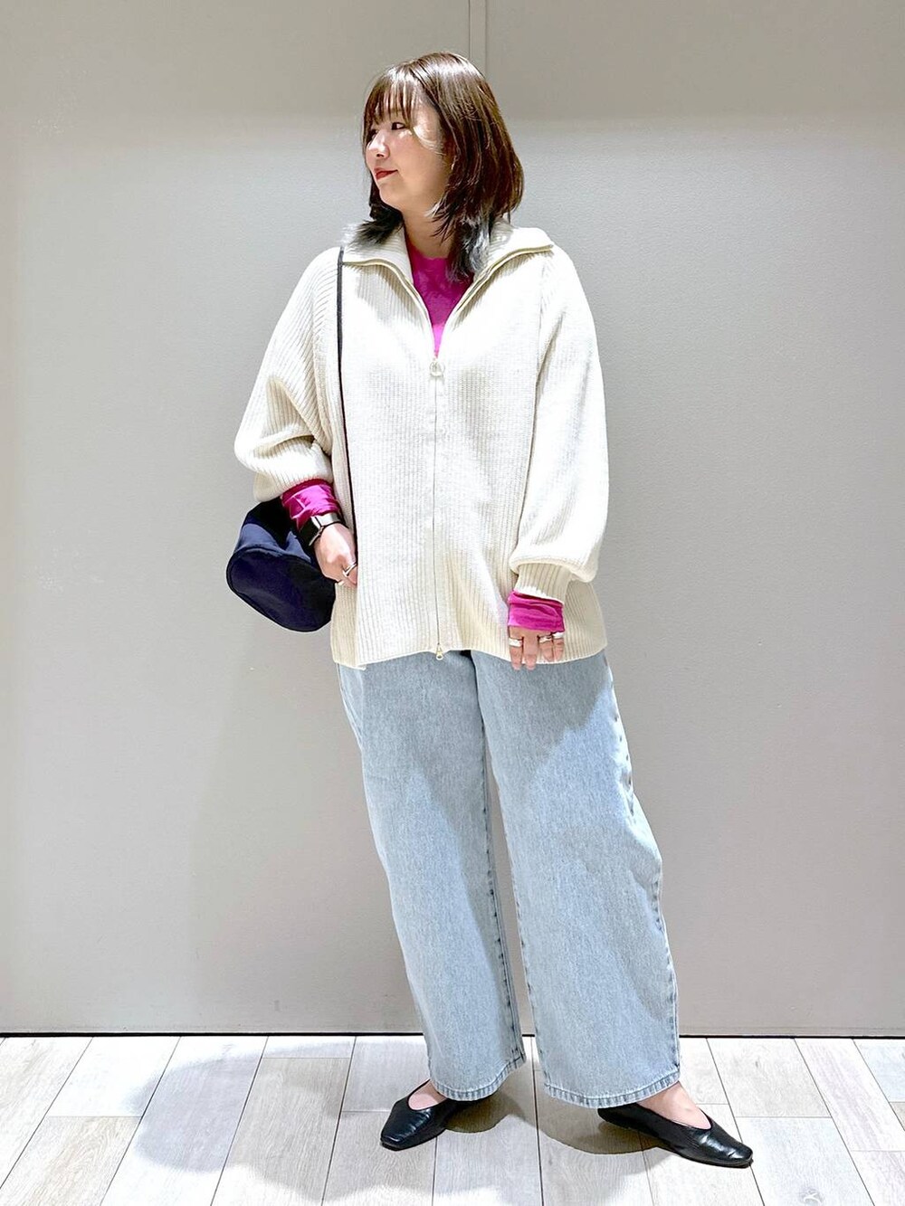 ホワイト系のニット/セーター、ブルー系のデニムパンツ、ブルー系のショルダーバッグを着用したレディースの冬コーディネートの4枚目の写真