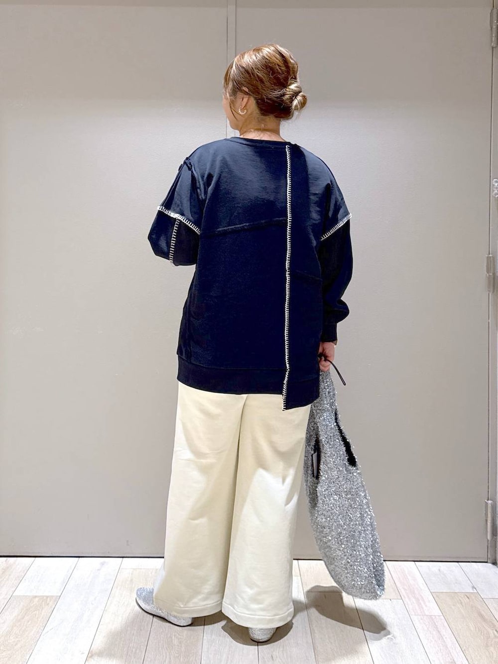 シルバー系のショルダーバッグ、グレー系のパンプス、ブラック系のワンピースを着用したレディースの冬コーディネートの3枚目の写真