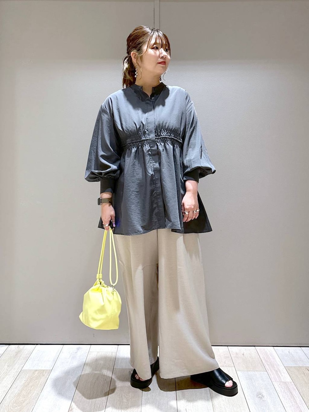 グレー系のシャツ/ブラウス、イエロー系のショルダーバッグ、ブラック系のサンダルを着用したレディースの春コーディネートの5枚目の写真