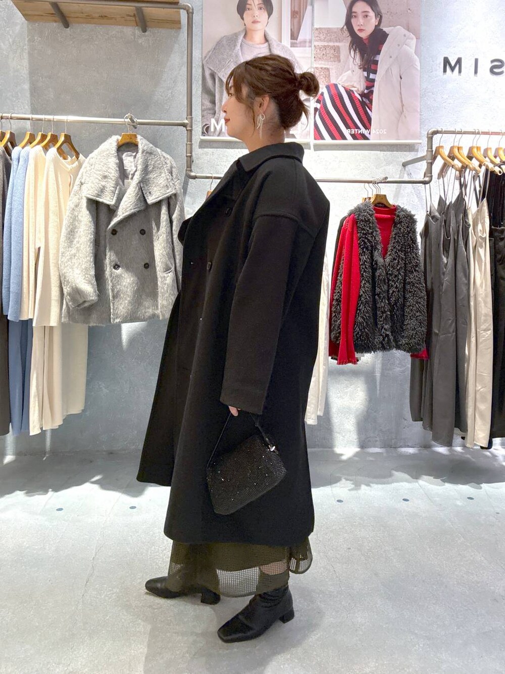 ブラック系のその他アウター、ブラック系のブーツ、グリーン系のドレスを着用したレディースの秋コーディネートの4枚目の写真