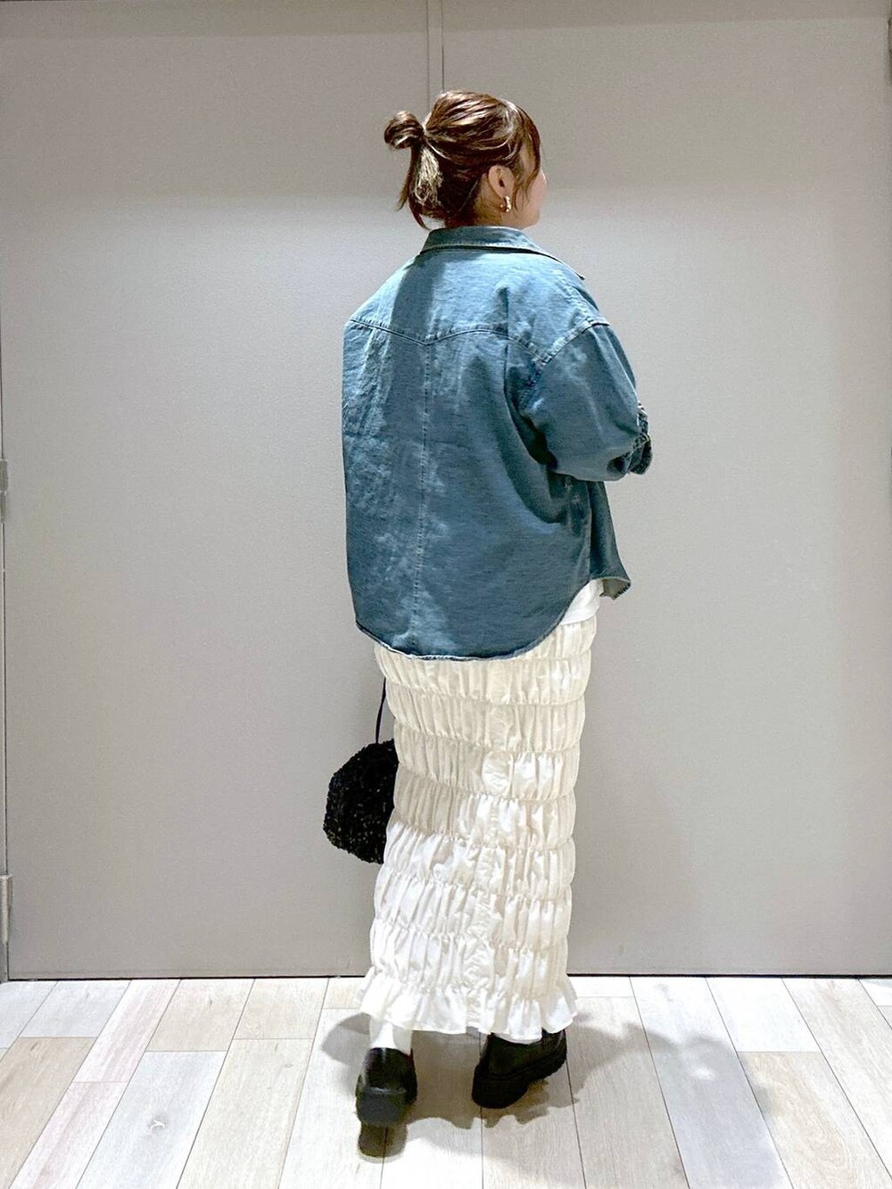 ホワイト系のスカート、ブラック系のローファー、ブラック系のショルダーバッグを着用したレディースの秋コーディネートの3枚目の写真