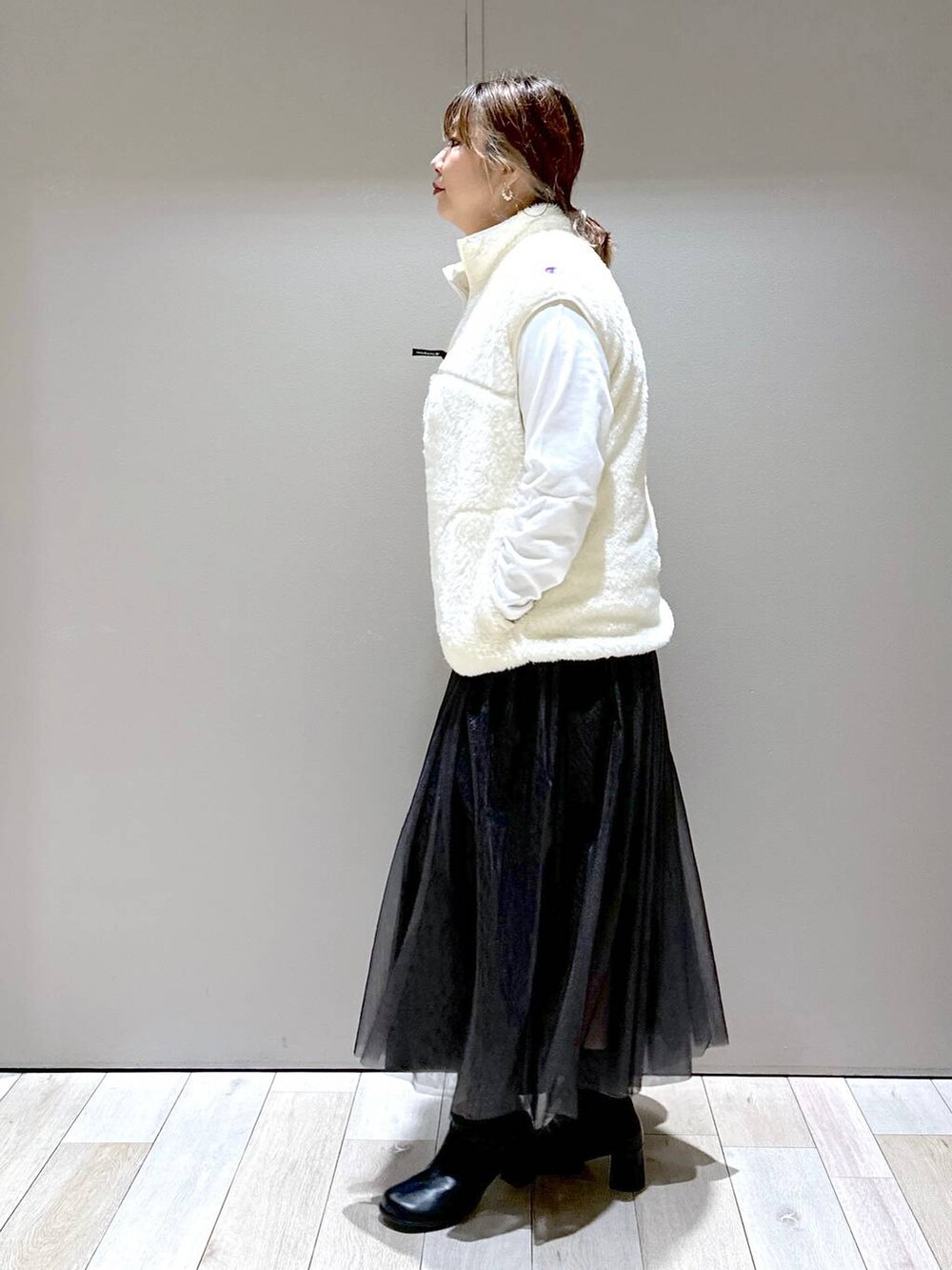 ホワイト系のその他アウター、ブラック系のブーツ、ホワイト系のTシャツ/カットソーを着用したレディースの秋コーディネートの2枚目の写真