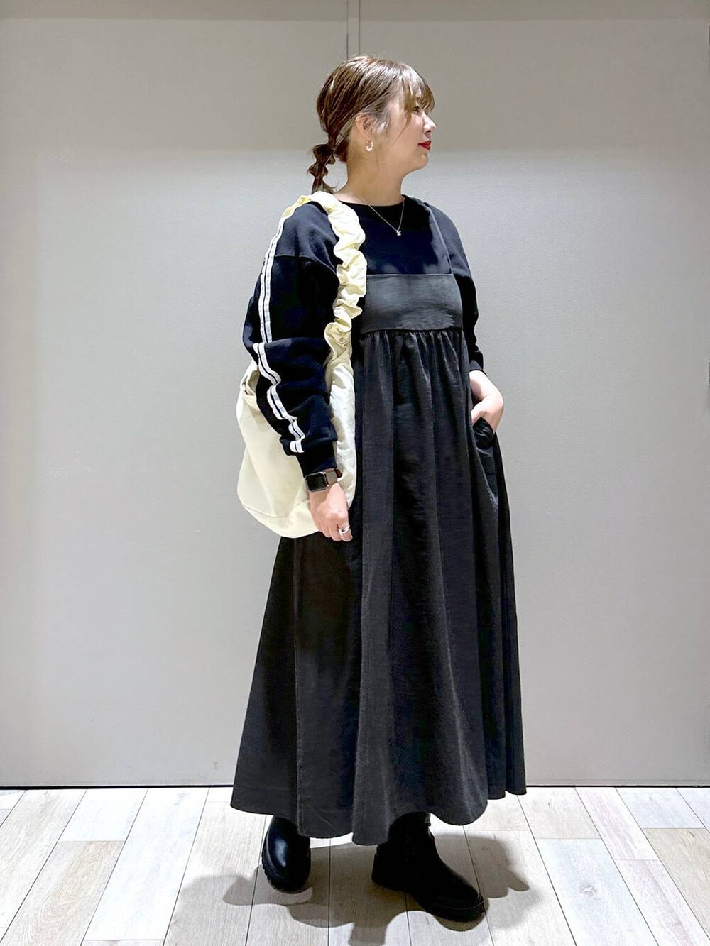 ブラック系のブーツ、ホワイト系のショルダーバッグ、ブラック系のTシャツ/カットソーを着用したレディースの秋コーディネートの4枚目の写真