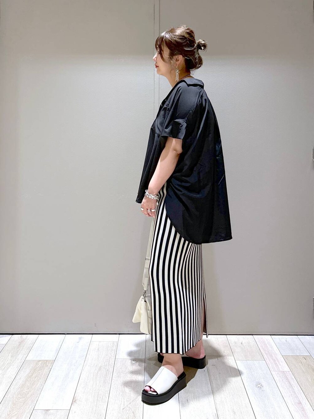 ホワイト系のショルダーバッグ、ブラック系のシャツ/ブラウス、ホワイト系のスカートを着用したレディースの春コーディネートの4枚目の写真