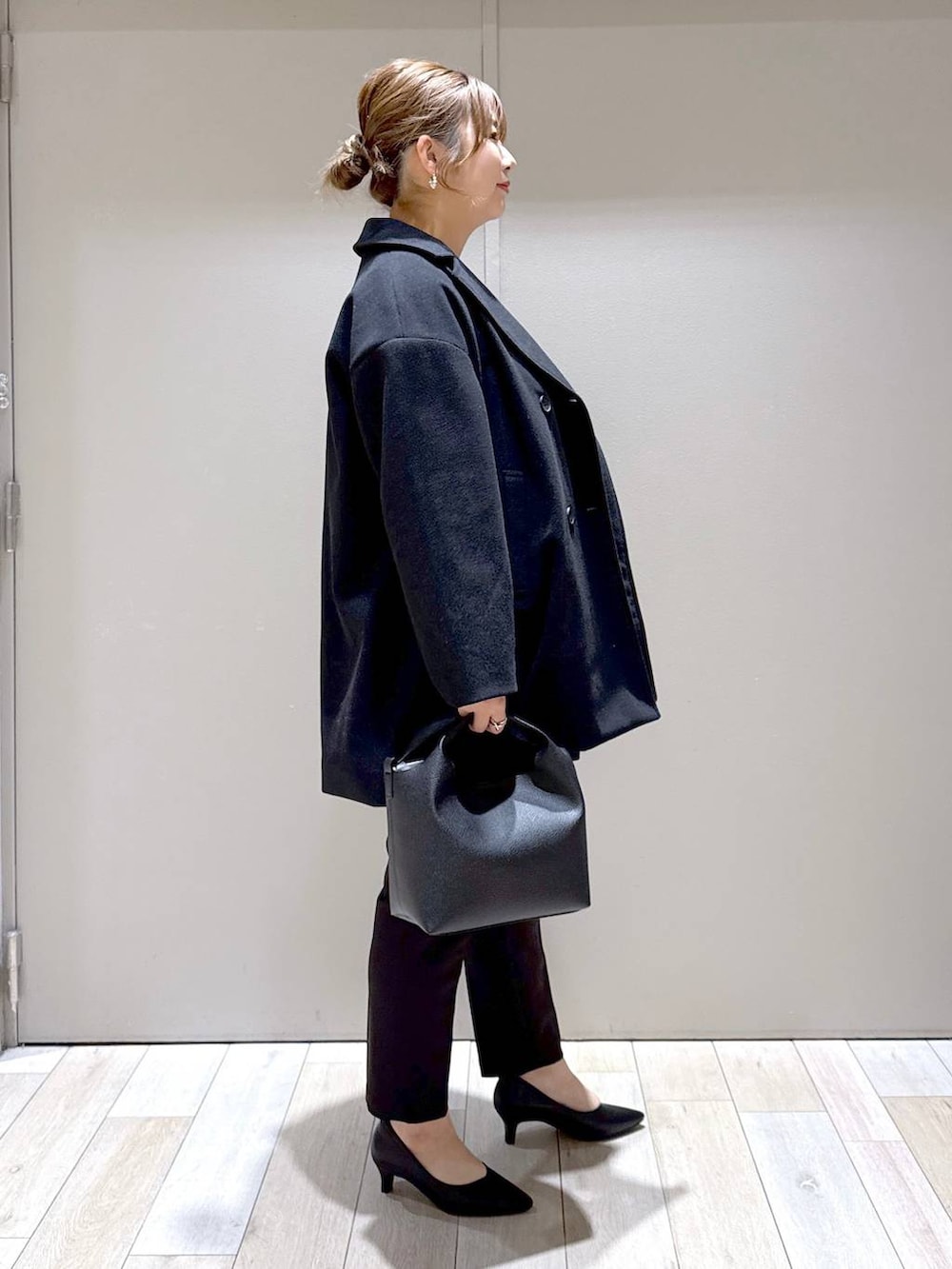 ブラック系のスーツパンツ、ブラック系のスーツベスト、ブルー系のシャツ/ブラウスを着用したレディースの冬コーディネートの2枚目の写真