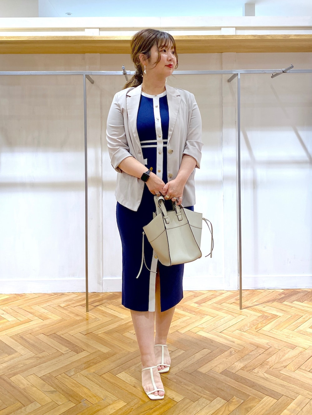 ブルー系のワンピース、グレー系のテーラードジャケット、グレー系のショルダーバッグを着用したレディースの春コーディネートの2枚目の写真
