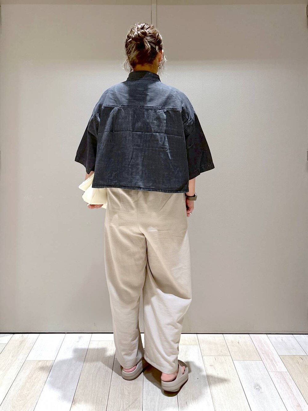 ホワイト系のショルダーバッグ、ベージュ系のその他パンツ、ブラック系のシャツ/ブラウスを着用したレディースの春コーディネートの3枚目の写真
