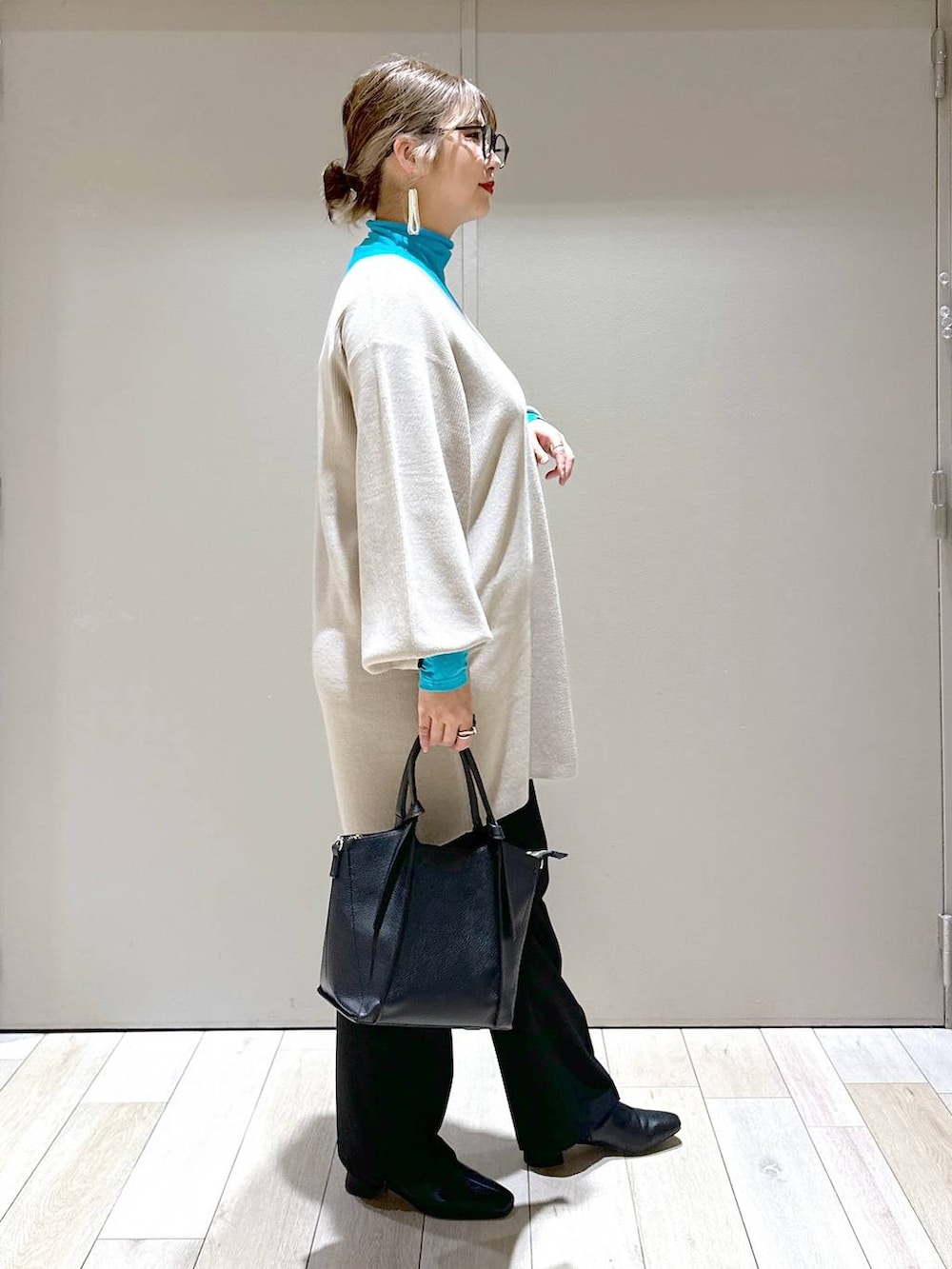 ブラック系のその他パンツ、ベージュ系のチュニック、ブラック系のショルダーバッグを着用したレディースの秋コーディネートの2枚目の写真