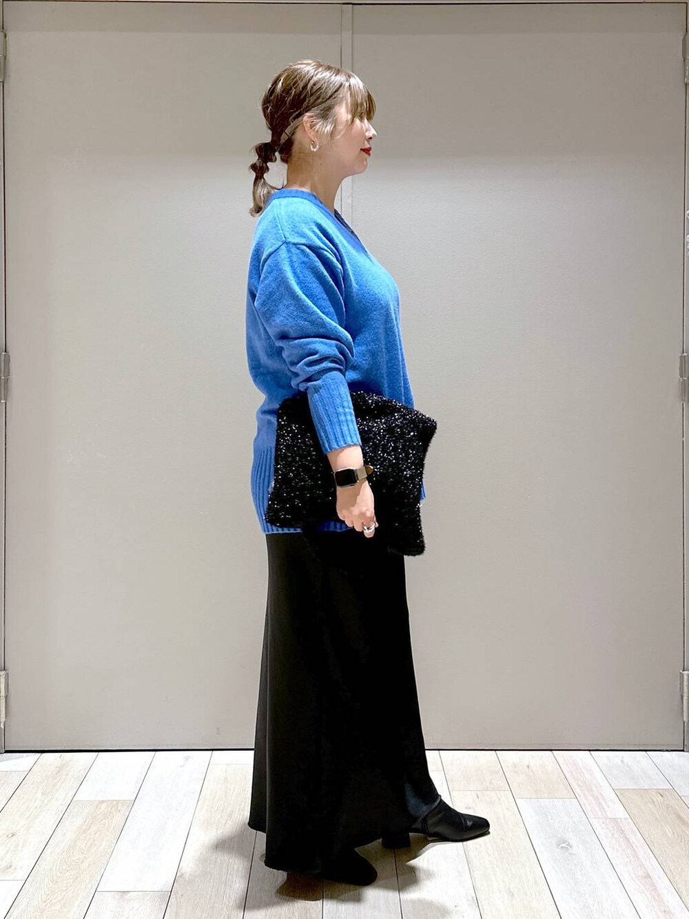 ブラック系のブーツ、ブラック系のショルダーバッグ、ブラック系のスカートを着用したレディースの秋コーディネートの2枚目の写真